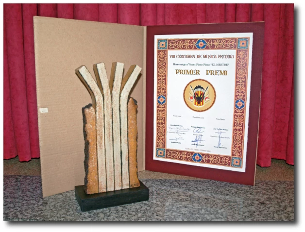 fotografia amb una composició formada per una imatge de l'estatueta del guardó, una imatge del certificat o diploma acreditatiu